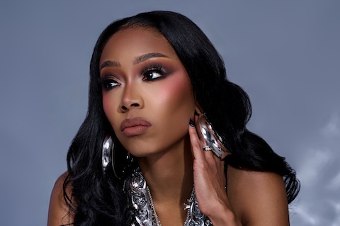 Close up of Crystal looking off to the side with her hand by her face